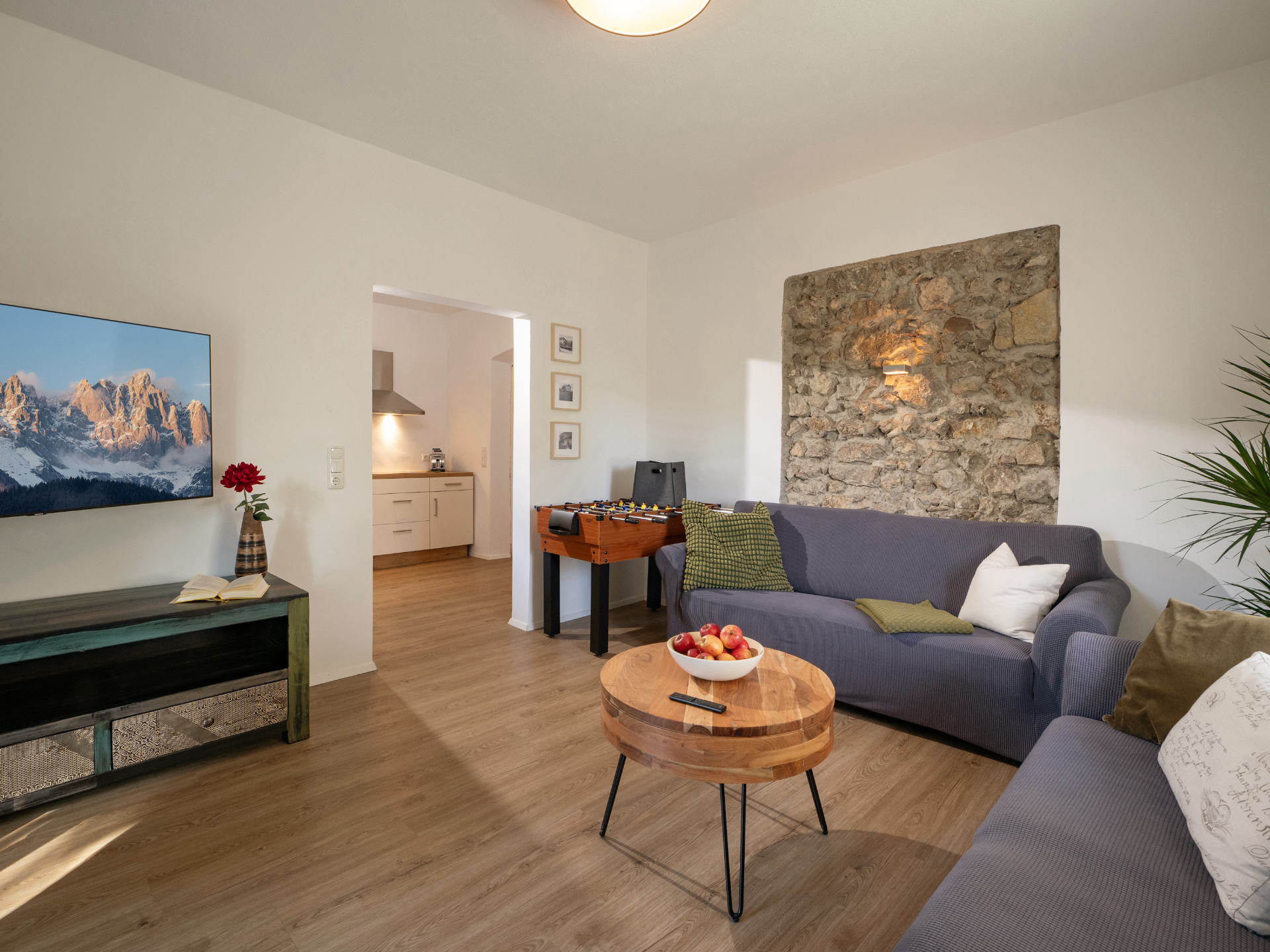 Wohnung 1 – Wohnzimmer mit Sofa und Durchgang zur Küche